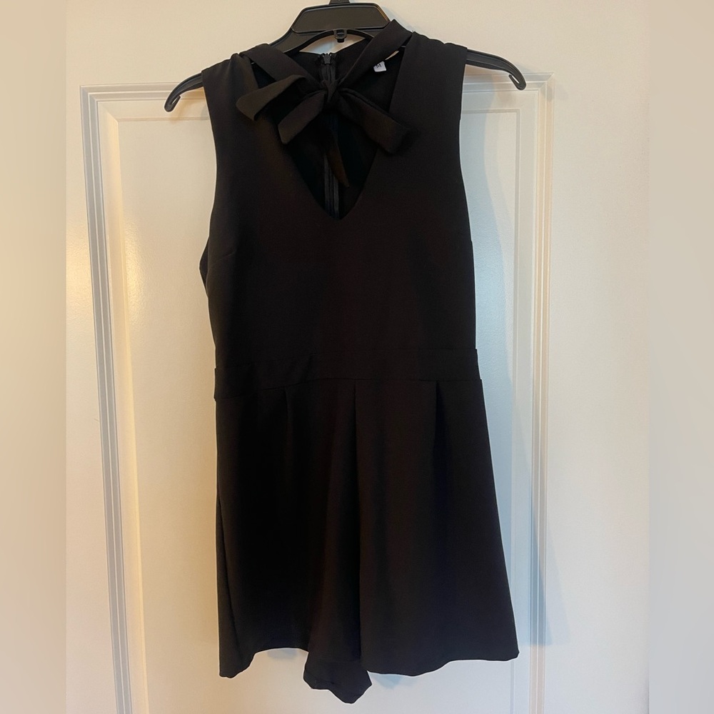 The Vanity room romper short. Black M romper with a plunging V-neck and bow